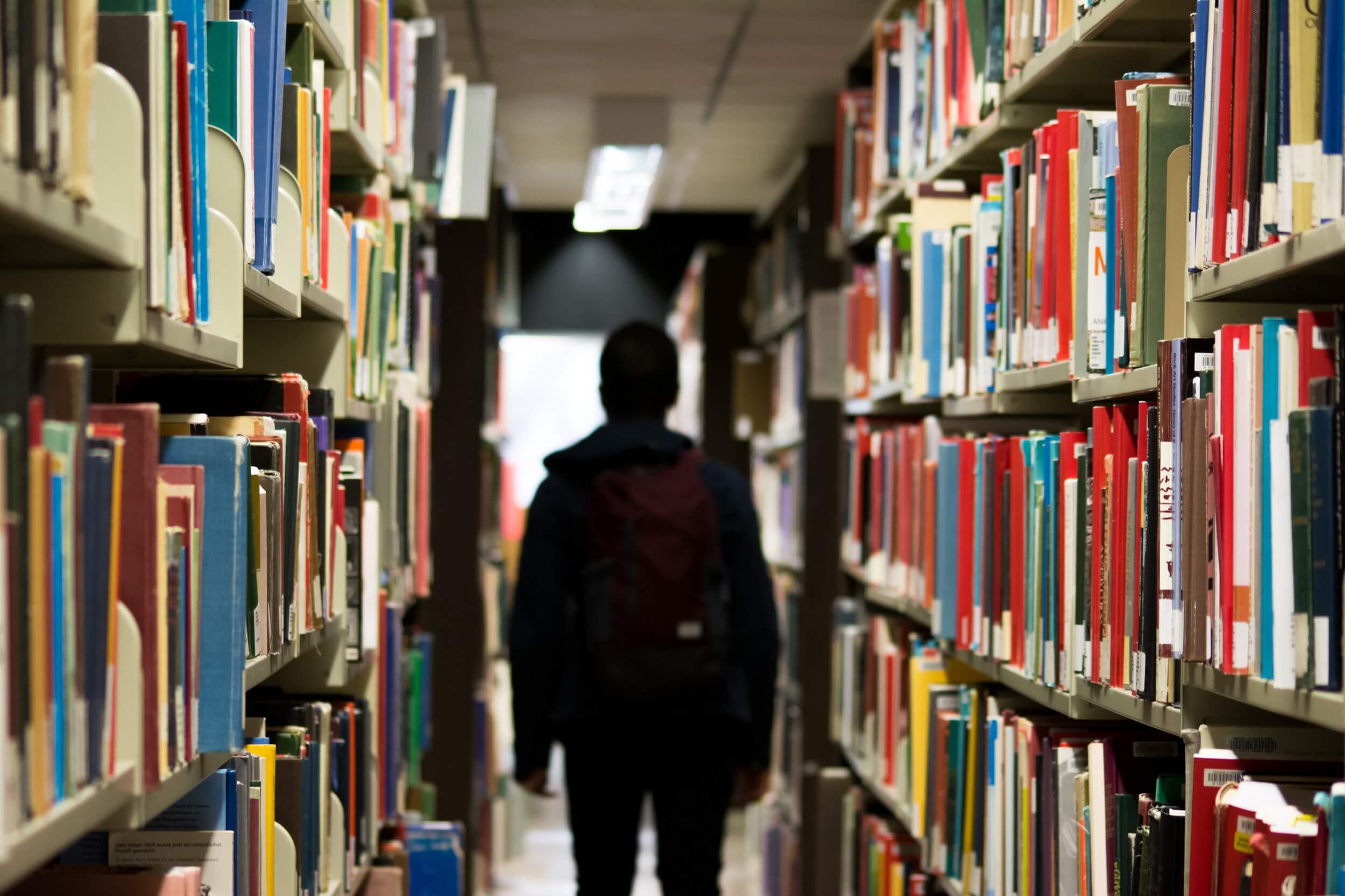 man with backpack in a library