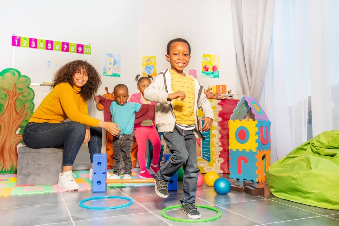 Kids jump from ring to another in nursery school.