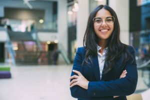Happy successful businesswoman posing in office hall.