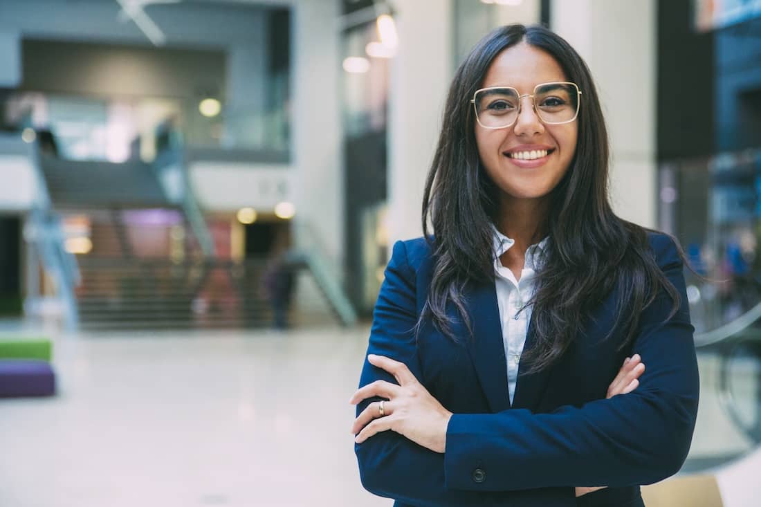 Happy successful businesswoman posing in office hall.