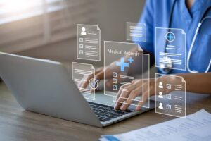 Doctor using laptop to manage electronic medical records.